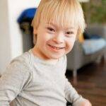 a young boy sitting in a chair with a smile on his face